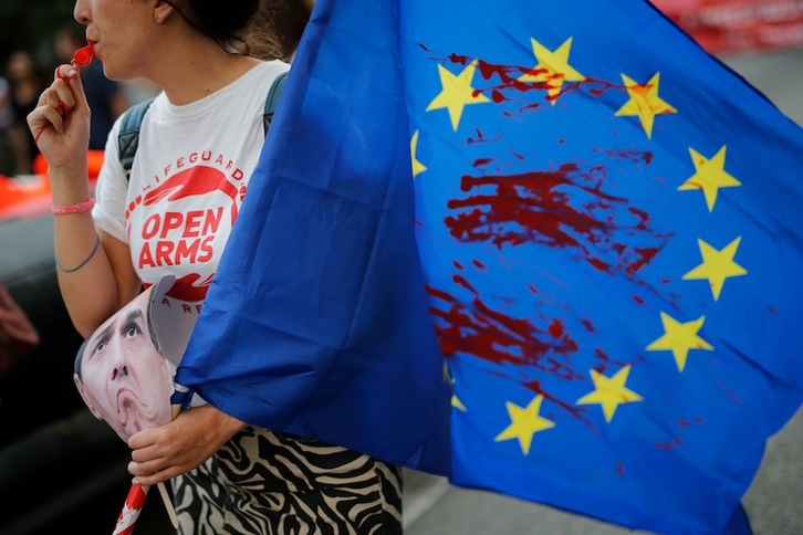 Una bandera de la UE ensangrentada, por el Open Arms en Barcelona. (Pau BARRENA | AFP)