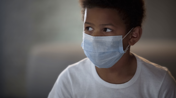 Un niño usa una mascarilla protectora en el hospital. (GETTY)