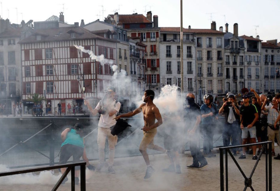 Manifestantes devuelven a la Policía los proyectiles de gas lacrimógeno. (Thomas SAMSON/AFP)