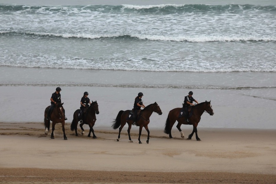 Los policías se suman al «picnic»: paseo a caballo por la playa. (Ludovic MARIN | AFP) (