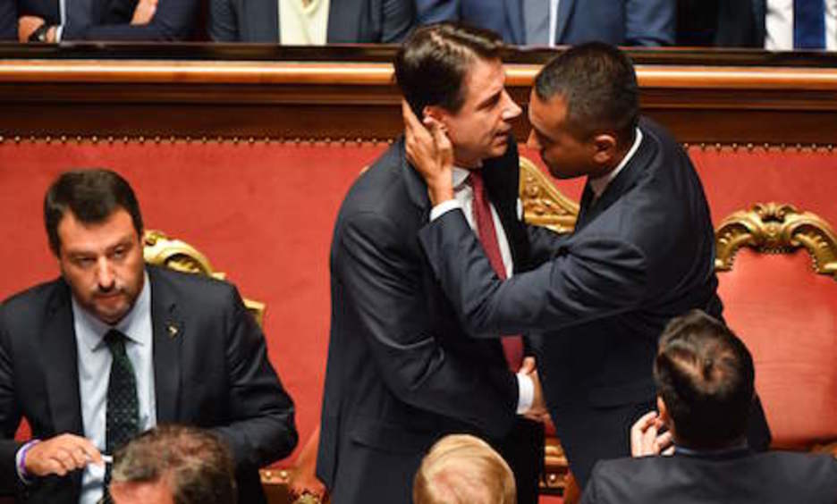 El líder del M5S, Luigi Di Maio, a la derecha, saluda al dimisionario primer ministro Giuseppe Conte. A la derecha, observa el líder de la Lega, Matteo Salvini. (Andreas SOLARO | AFP)