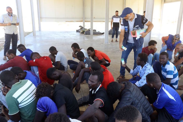 Los rescatados reciben ayuda alimentaria en Khoms. (Mahmud TURKIA /AFP)