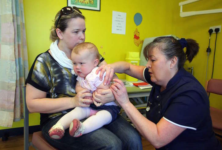 Una bebé de 14 meses recibe la vacuna de la triple vírica en un centro de salud de Swansea, en Gran Bretaña. (Geoff CADDICK/AFP)