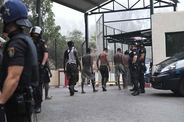 Migrantes detenidos tras haber logrado saltar la valla de Ceuta. (Antonio SEMPERE/AFP)