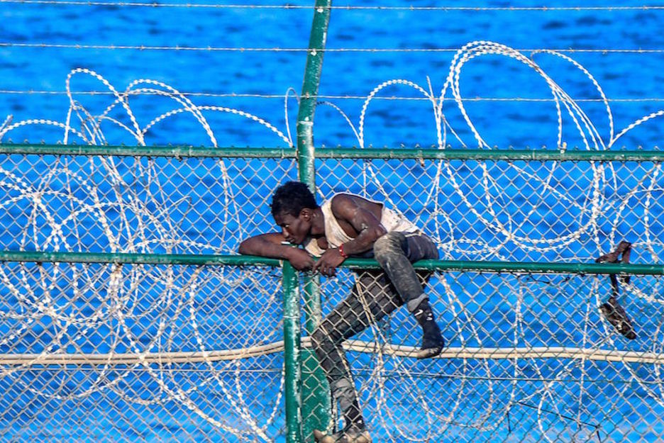 Uno de los migrantes atrapado por las concertinas que el Gobierno en funciones de Pedro Sánchez ha prometido retirar. (Antonio SEMPERE/AFP)
