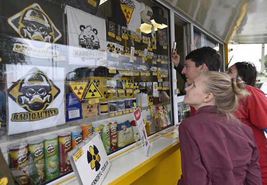Turistas compran recuerdos en un puesto de control del radio del 30 kilómetros en torno a la central nuclear de Chernóbil. (Genya SAVILOV/AFP)