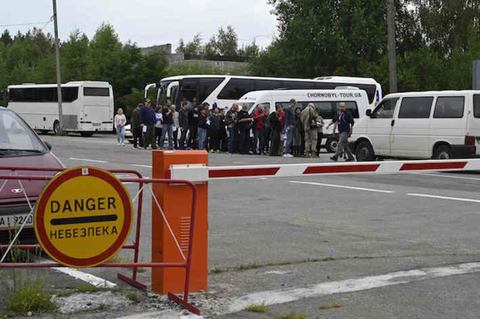 Turistas, junto a un puesto de control en las inmediaciones de la zona de exclusión. (Genya SAVILOV/AFP)