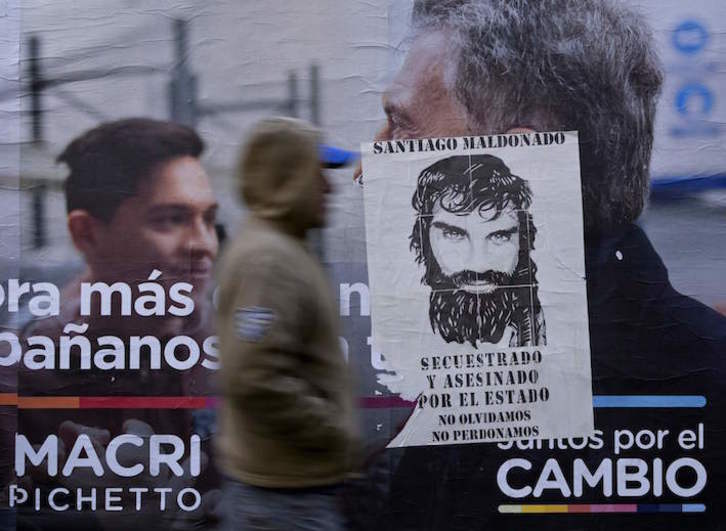 Un cartel electoral con el rostro de Macri, cubierto por otro que recuerda a Santiago Maldonado. (Juan MABROMATA/AFP)