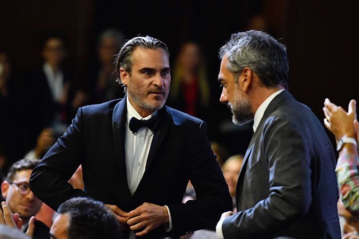 Joaquin Phoenix y Todd Phillips se dirigen a recoger el premio por ‘‘Joker’’. (Alberto PIZZOLI / AFP)