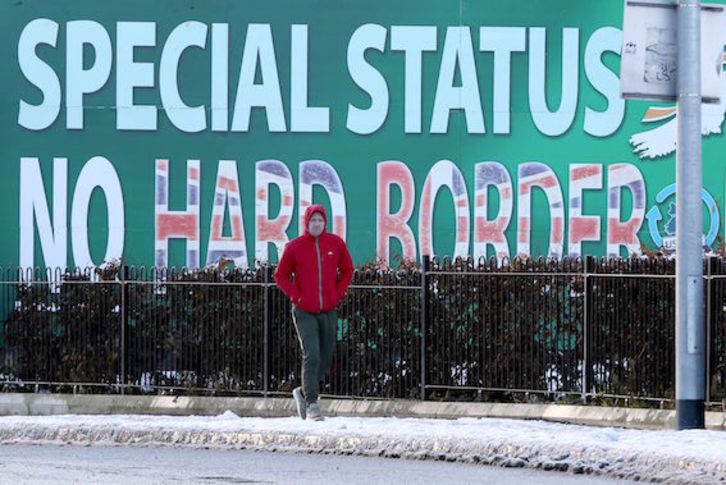 Un hombre pasa junto a un cartel que reclama en Belfast un estatus especial sin fronteras para el norte de Irlanda. (Paul FAITH/AFP)