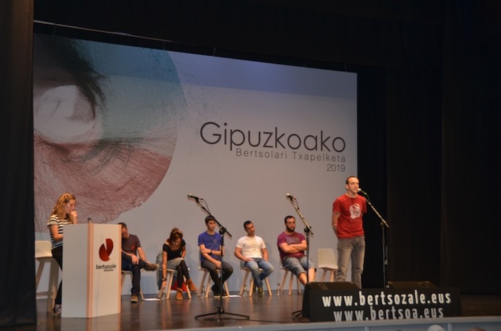 Beñat Iguaran saioko irabazlea kantuan, bertsokideak atzean dituela. (Gipuzkoako Bertsolari Txapelketa)