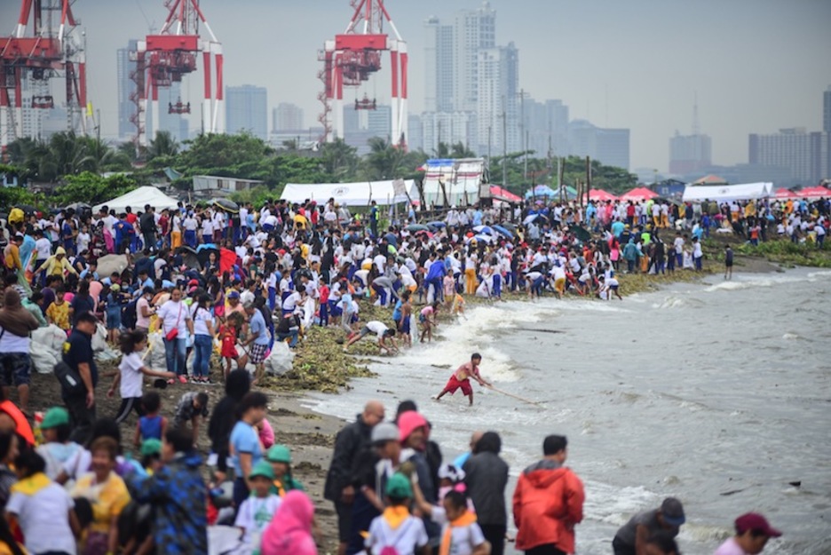 Cientos de voluntarios limpian una zona de costa en Manila (Filipinas) en la jornada. (Maria TAN | AFP)