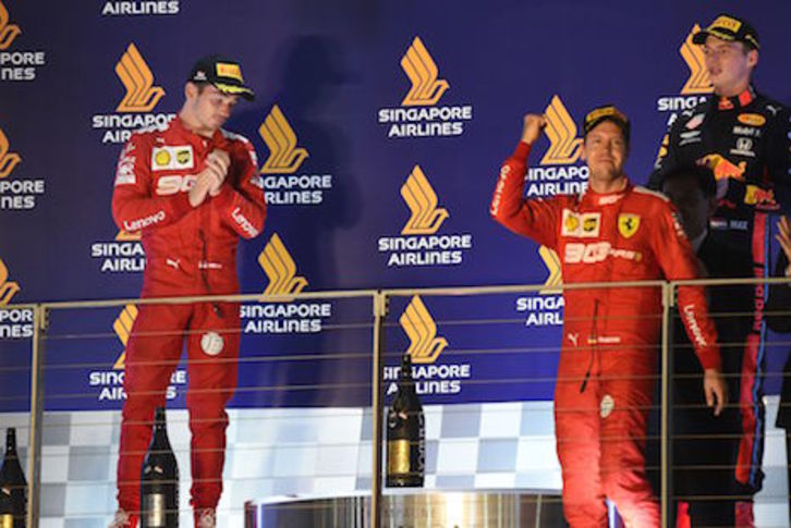 Vettel, a la derecha, celebra su triunfo ante la cara de circunstancias de Leclerc. (Roslan RAHMAN/AFP PHOTO)