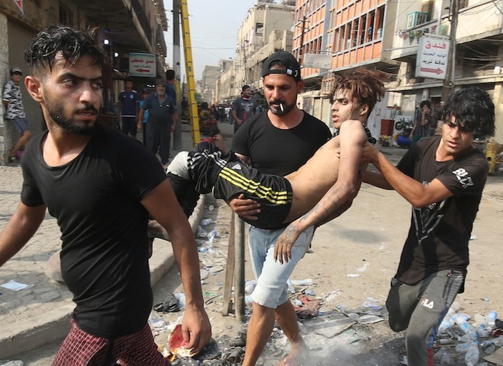 Llevan a un joven herido en las protestas en Bagdad. (AHMAD AL-RUBAYE I AFP)