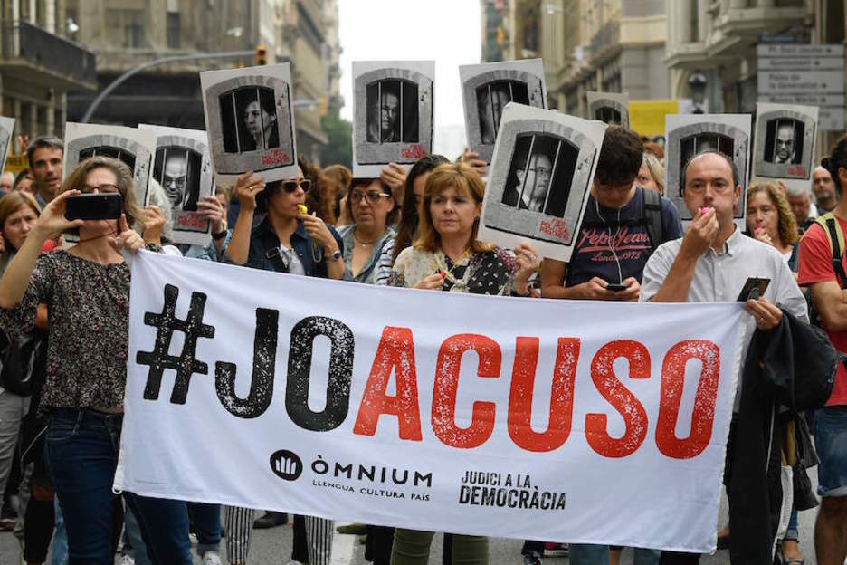 Manifestantes despliegan una pancarta con el lema «Yo acuso» en Barcelona (Lluís GENÉ/AFP)