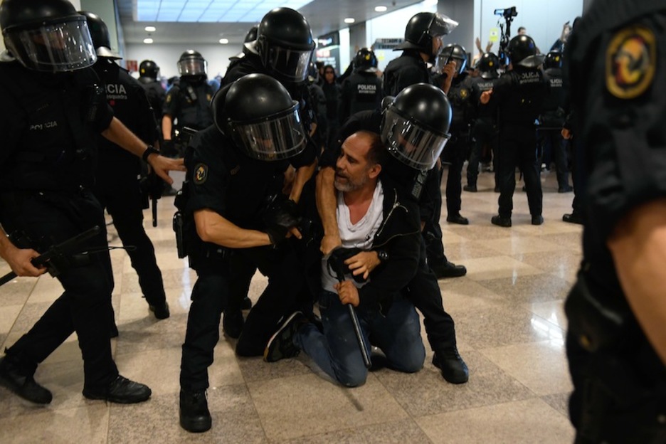 Carga policial en la T1 de El Prat, donde había Mossos y policías españoles. (Josep LAGO | AFP)