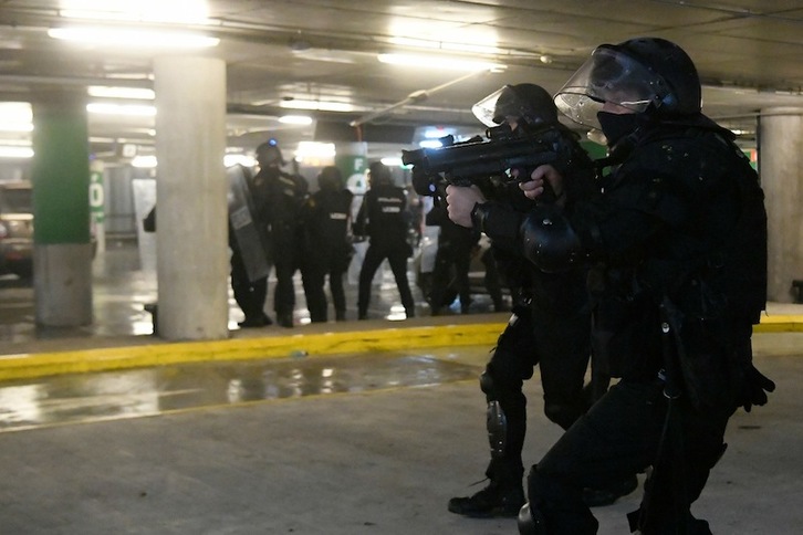 Policías españoles, disparando el lunes en el aeropuerto. (Lluís GENÉ | AFP)