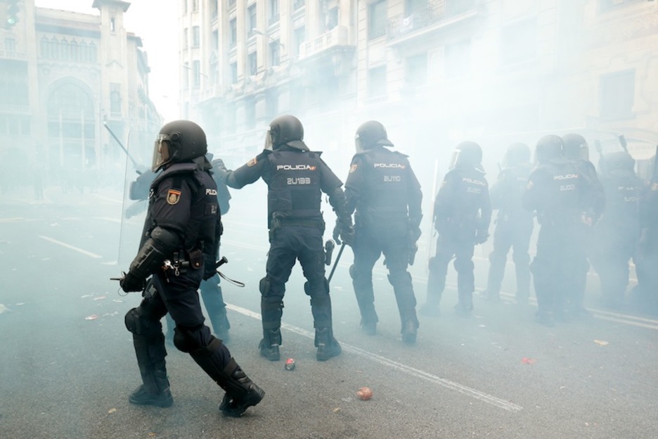 Policías españoles, entre el humo en enfrentamientos en Via Laietana. (Pau BARRENA | AFP)