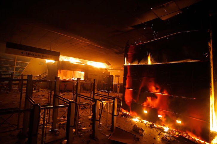 Las llamas consumen una estación del metro en Santiago de Chile. (JAVIER TORRES / AFP)