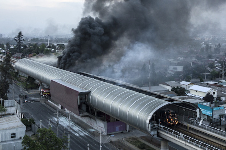 Humo y fuego en una estación del suburbano de Santiago. (Javier TORRES / AFP)