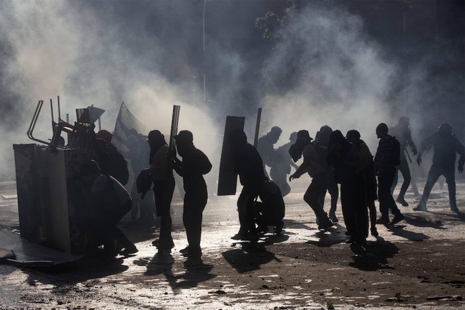 Paisaje de humo, en los altercados que el presidente tilda de «guerra». (Claudio REYES | AFP)