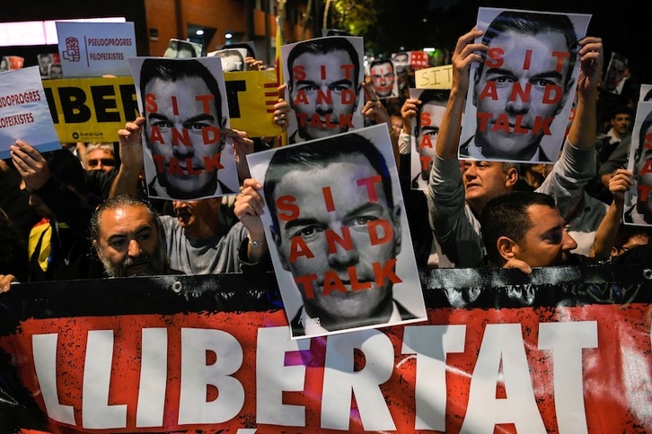 Carteles contra Pedro Sánchez a su llegada a Viladecans. (Josep LAGO | AFP)