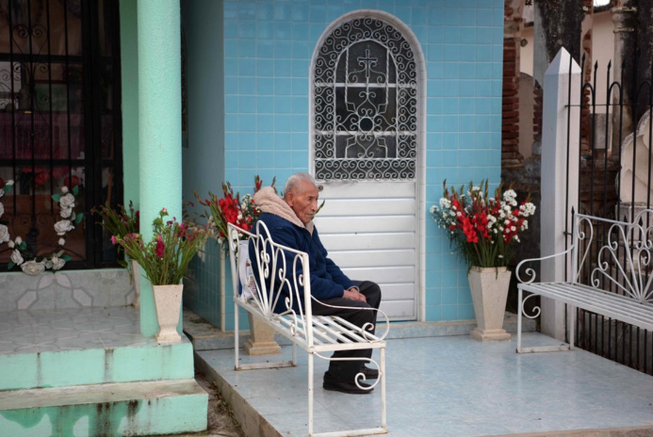 Un hombre descansa junto a una tumba. (Agustin PAULLIER / AFP)