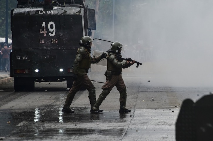Soldados chilenos disparando en Santiago. (Rodrigo ARANGUA | AFP)