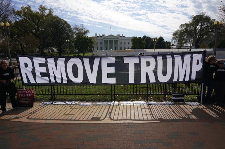Activistas muestran una pancarta a favor de la destitución de Trump ante la Casa Blanca. (Mandel NGAN/AFP)