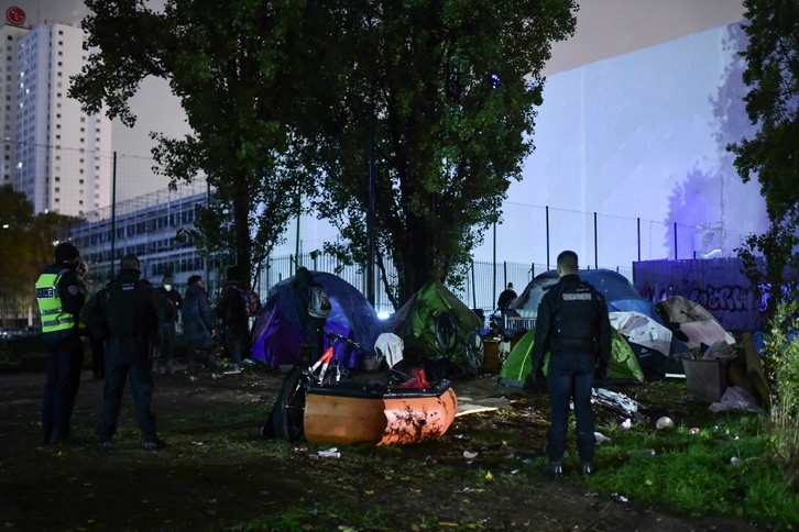 Policías franceses desmontan un campamento de refugiados en París. (Martin BUREAU / AFP)