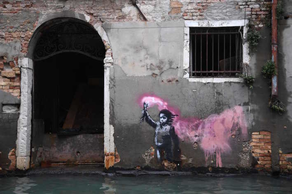 Una obra de Banksy que muestra a una pequeña migrante, a punto de ser alcanzada por el agua. (Marco BERTORELLO/AFP)