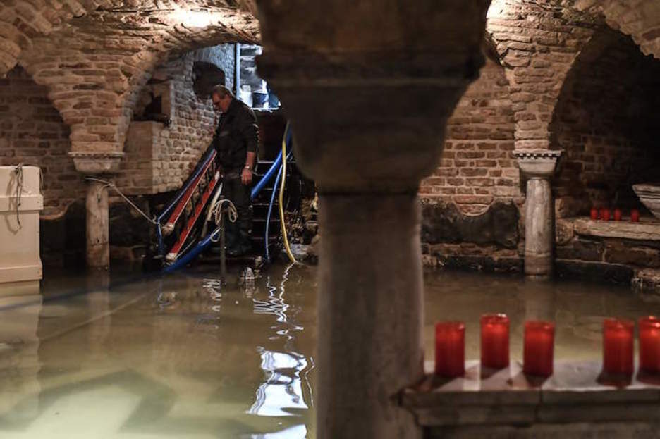 Un operario bombea agua de la cripta de la basílica. (Marco BERTORELLO/AFP)
