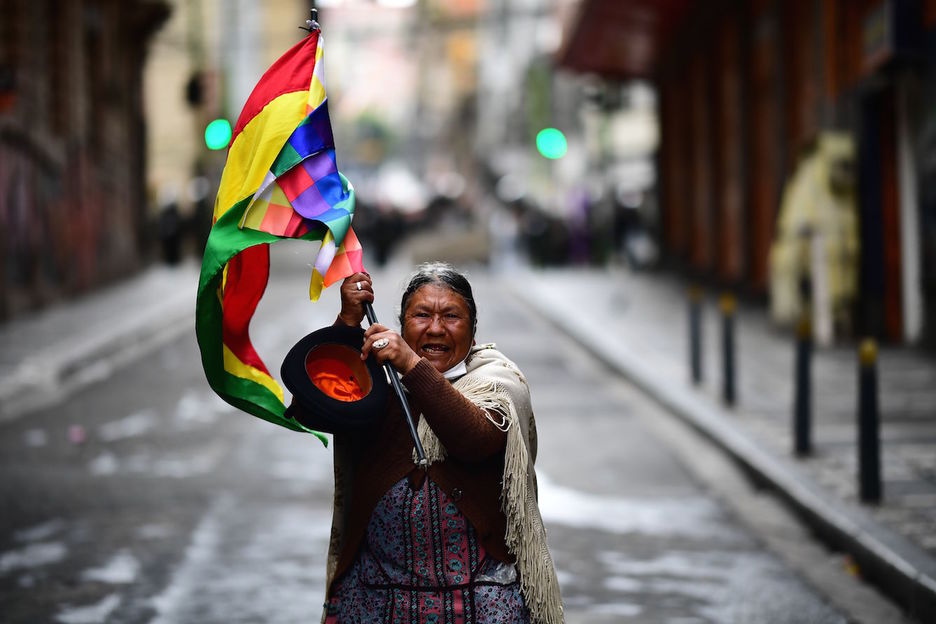 Una mujer con una bandeja wiphala en La Paz. (Ronaldo SCHEMIDT/AFP)