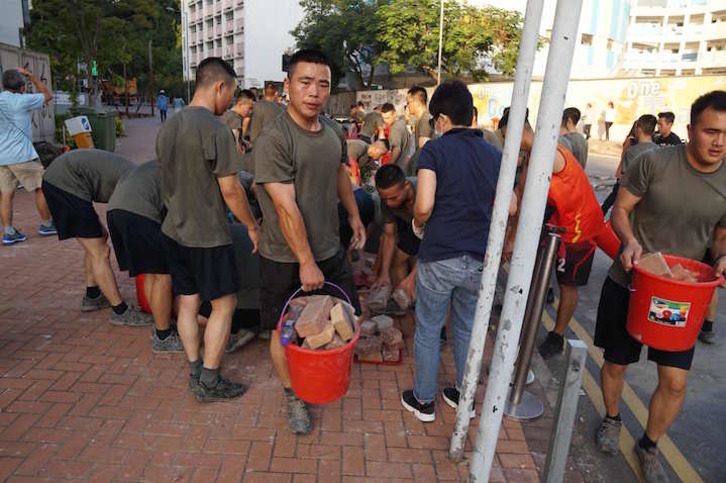 Soldados chinos recogen ladrillos y escombros. (AFP)