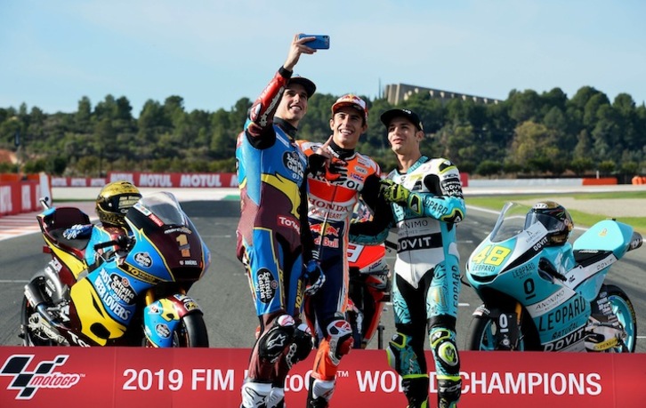 Alex Márquez, campeón de Moto2; Marc Márquez, el de MotoGP; y Lorenzo dalla Porta, el de Moto3, se sacan la foto de campeones (José JORDÁN / AFP)