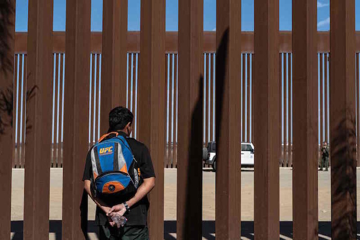 Un menor inmigrante de Guatemala observa desde la localidad mexiana de Tijuana la valla fronteriza entre México y EEUU. (Guillermo ARIAS/AFP)