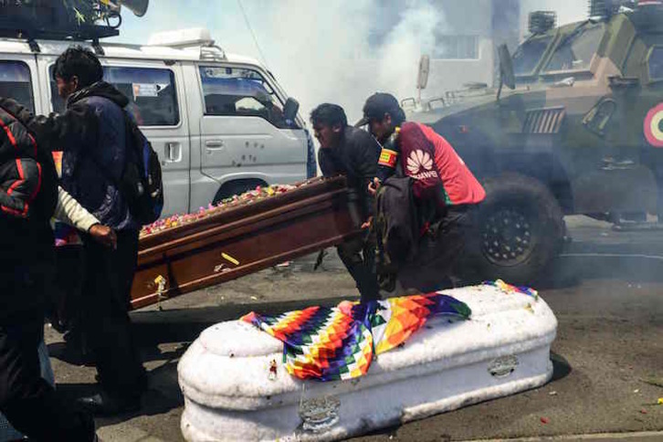 Manifestantes dejan los féretros en el suelo entre gases lacrimógenos. (Ronaldo SCHMEDIT/AFP)