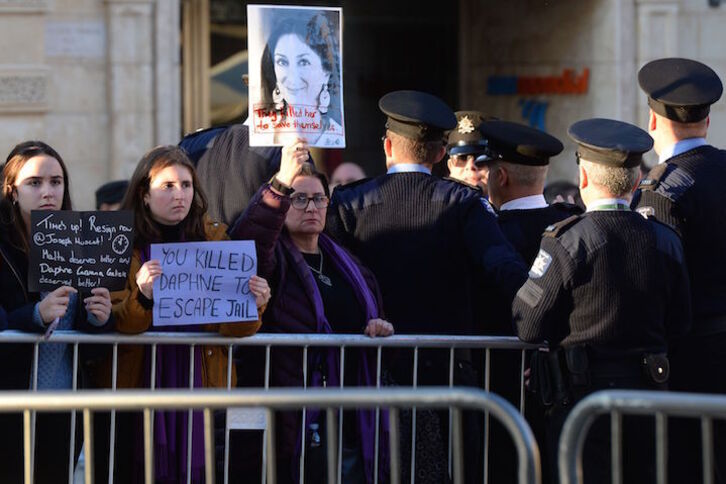 Manifestantes con fotografías de Daphne Caruana, en el exterior del Parlamento maltés. (Matthew MIRABELLI/AFP)