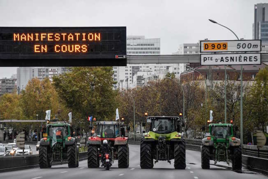 Cuatro tractores ocupan todo el ancho de la calzada. (Bertrand GUAY / AFP)