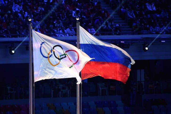 La bandera olímpica y la de Rusia en la ceremonia de clausura de los juegos de invierno de Sochi. (Andrej ISAKOVIC/AFP)