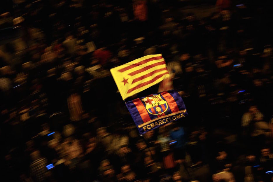 Una estelada y una bandera del Barça ondean entre el público. (Pau BARRENA/AFP)