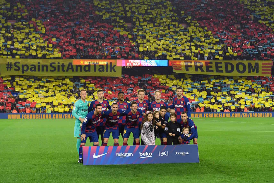 Los jugadores del Barça posan con las reivindicaciones de la grada detrás. (Josep LAGO/AFP)