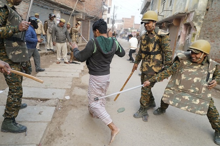 Un policía golpea a un manifestante en Varanasi. (AFP)