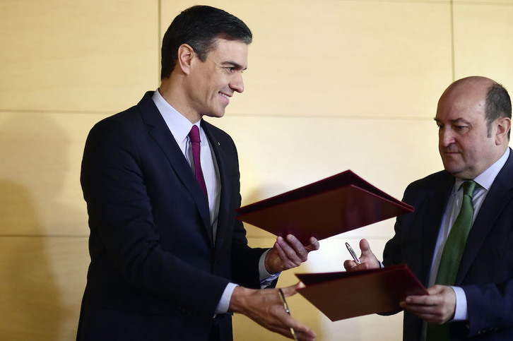 Pedro Sánchez y Andoni Ortuzar se intercambian el acuerdo. (Oscar del POZO/AFP)