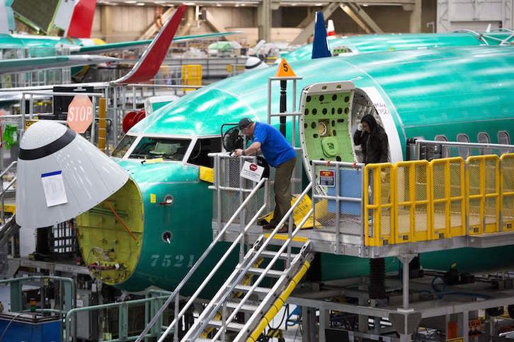 Trabajadores de Boeing revisando un 737 Max (Jason REDMOND/AFP)