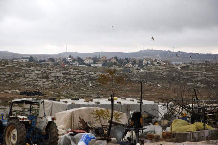 Tiendas y chabolas palestinas frente a una colonia israelí en Cisjordania. (Hazem BADER/AFP