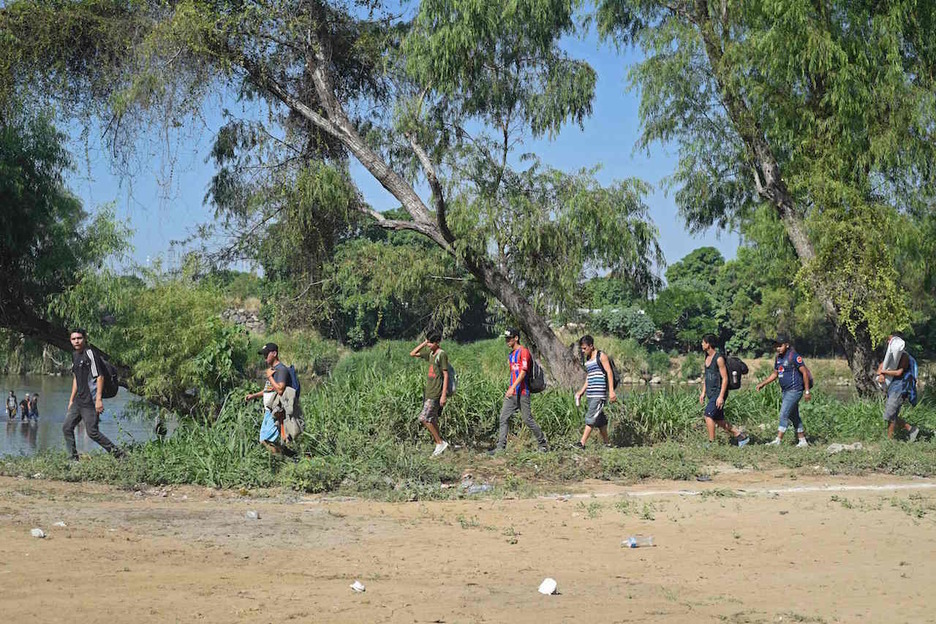 Caminando por la orilla del río Suchiate. (Alfredo ESTRELLA/AFP)