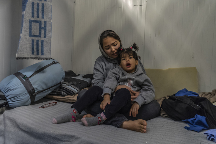 Shamseyeh, refugiada afgana de 23 años, junto a su hija Zahra, de 6, que sufre autismo en la habitación compartida en el campamento de Moria. (Anna PANTELIA/MSF)
