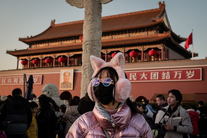 Una mujer se protege con una mascarilla en la Puerta de Tiananmen, en Pekín. (Nicolas ASFOURI / AFP)
