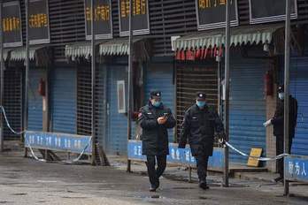 Agentes patrullando en el mercado de Wuhan, epicentro del coronavirus. (Hector RETAMAL/AFP)